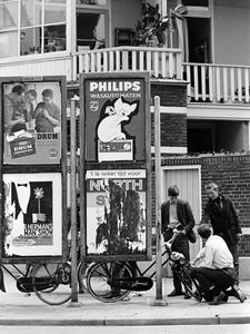 361212 Afbeelding van drie jongens bij een solex tegen een rek met reclameaffiches in de Abel Tasmanstraat te Utrecht, ...